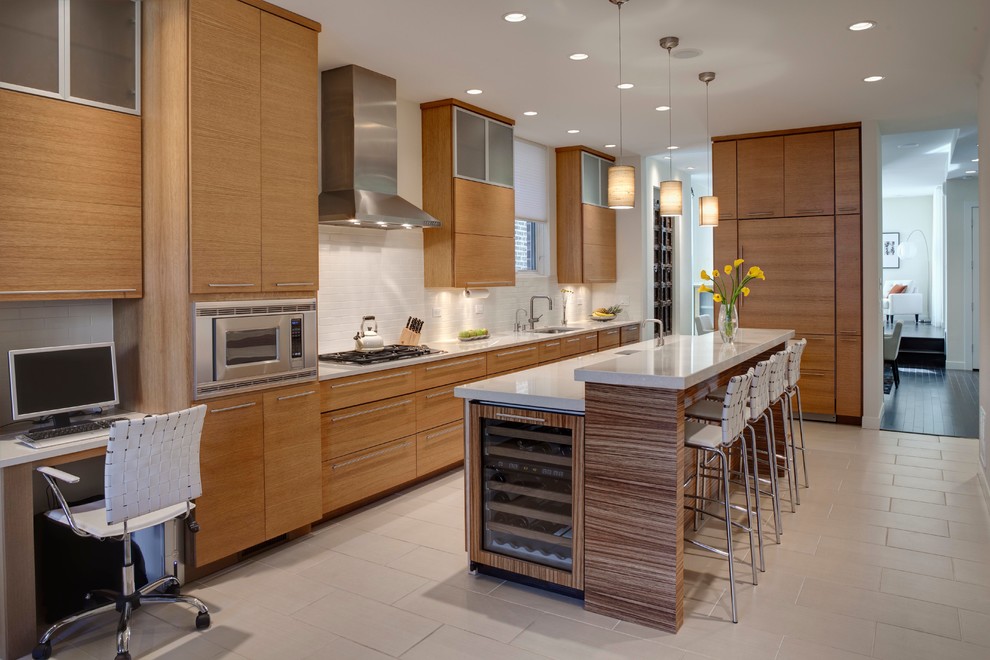 Cette image montre une cuisine parallèle et encastrable design en bois brun avec un évier encastré, un placard à porte plane, une crédence blanche et une crédence en carrelage métro.
