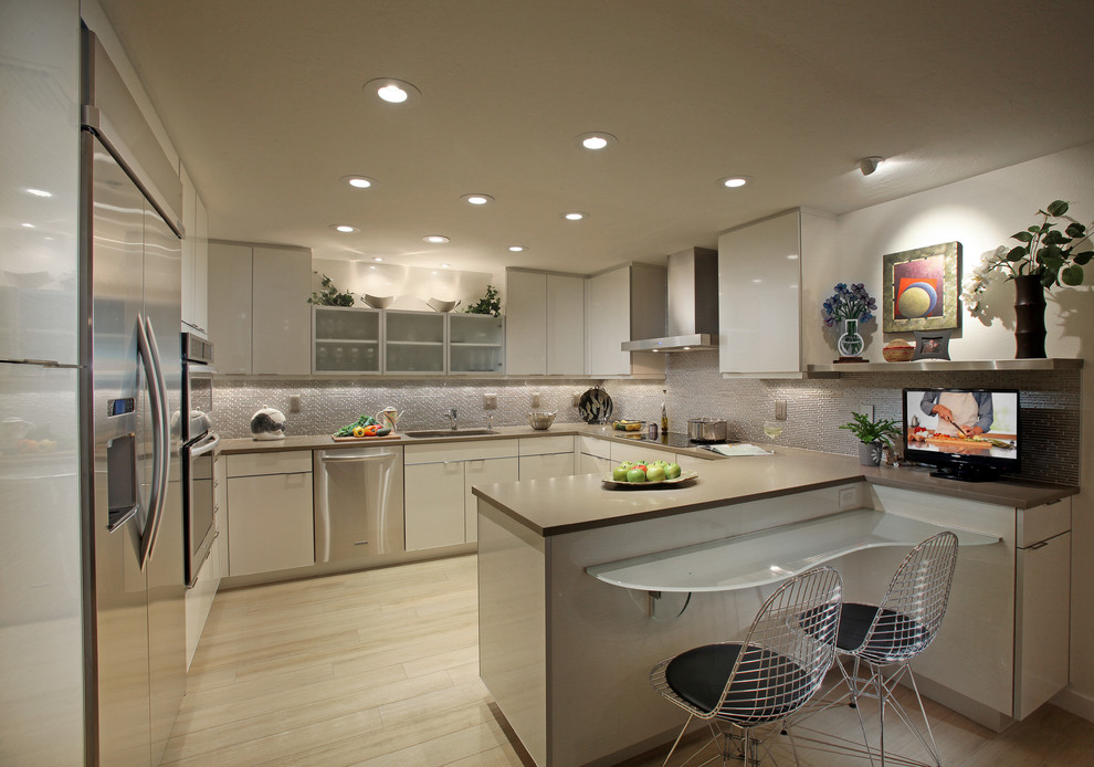 Immagine di una cucina minimal di medie dimensioni con lavello a vasca singola, ante in stile shaker, top in acciaio inossidabile, elettrodomestici in acciaio inossidabile e penisola