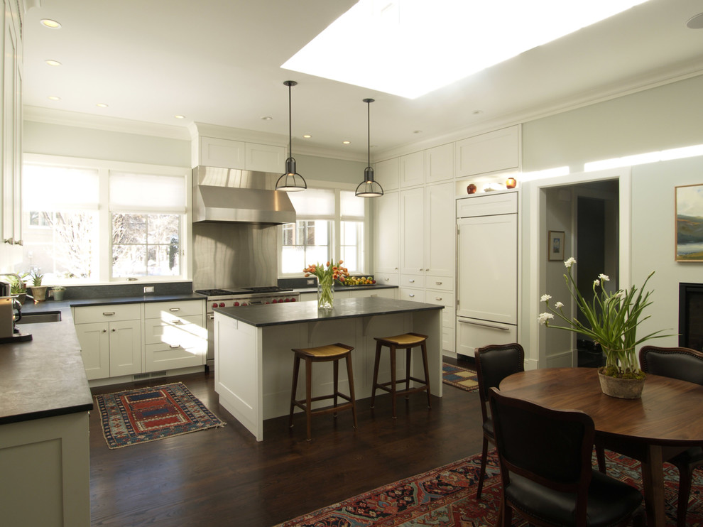 Imagen de cocinas en U moderno cerrado con armarios estilo shaker, puertas de armario blancas, electrodomésticos con paneles, suelo de madera oscura y una isla