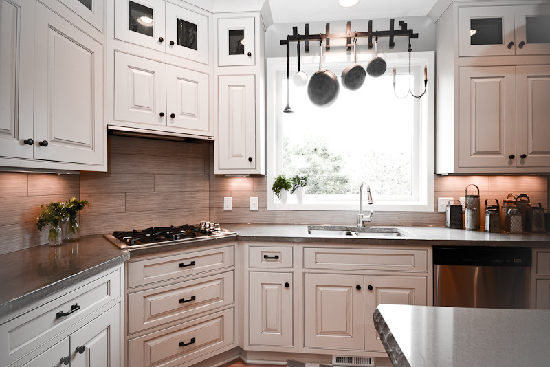 Inspiration for a large traditional l-shaped kitchen/diner in Minneapolis with a submerged sink, raised-panel cabinets, white cabinets, concrete worktops, grey splashback, porcelain splashback, stainless steel appliances, medium hardwood flooring and an island.
