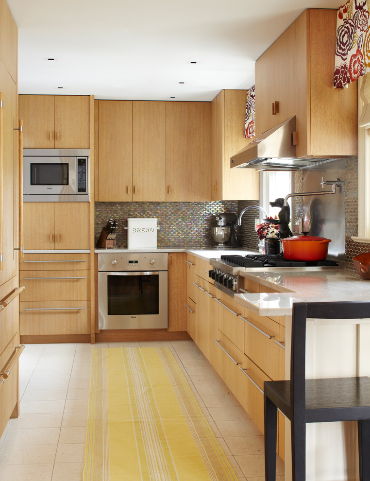 Immagine di una cucina contemporanea con ante lisce, ante in legno chiaro e elettrodomestici in acciaio inossidabile