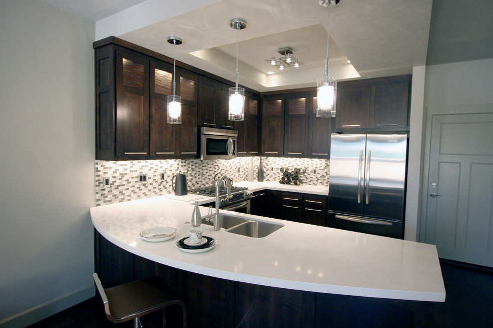 Example of a mid-sized minimalist u-shaped medium tone wood floor eat-in kitchen design in Portland with an undermount sink, shaker cabinets, dark wood cabinets, quartz countertops, multicolored backsplash, mosaic tile backsplash, stainless steel appliances and a peninsula