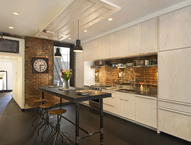 Immagine di una cucina minimalista di medie dimensioni con ante lisce, ante in legno chiaro, top in acciaio inossidabile, lavello da incasso e elettrodomestici in acciaio inossidabile
