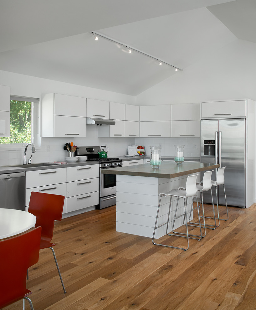 Exempel på ett modernt kök och matrum, med släta luckor, vita skåp, träbänkskiva, vitt stänkskydd, stänkskydd i keramik, rostfria vitvaror, mellanmörkt trägolv och en köksö