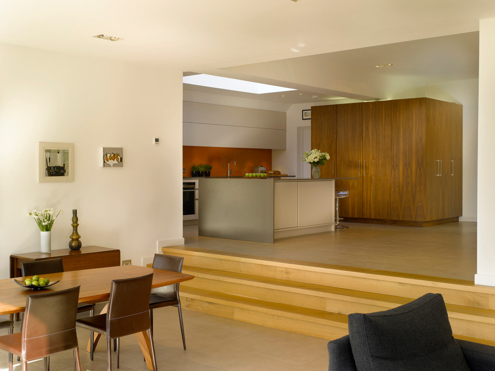 Exempel på ett stort modernt kök med öppen planlösning, med en köksö, släta luckor, vita skåp, bänkskiva i koppar, orange stänkskydd, glaspanel som stänkskydd och en undermonterad diskho