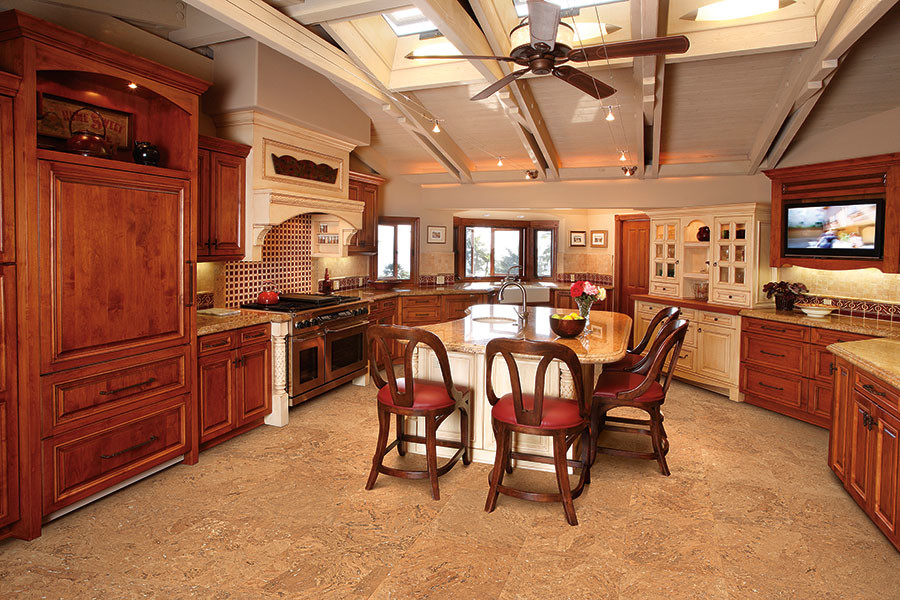 Foto di una cucina american style di medie dimensioni con lavello sottopiano, ante con bugna sagomata, ante in legno scuro, elettrodomestici in acciaio inossidabile e pavimento in sughero