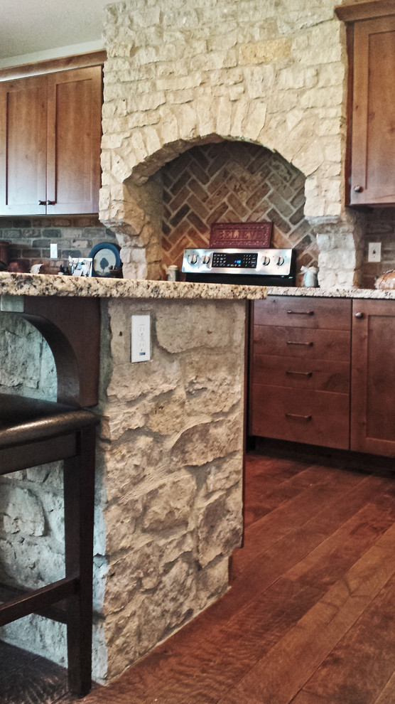 Foto di una cucina chic di medie dimensioni con ante con riquadro incassato, ante in legno bruno, elettrodomestici in acciaio inossidabile e parquet scuro