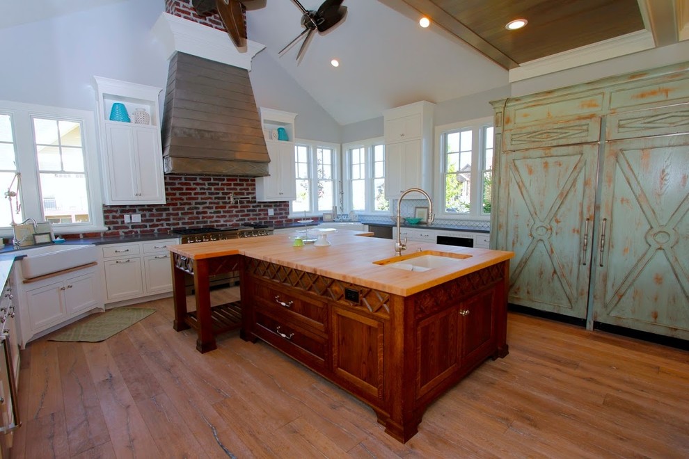 Inspiration for a huge country galley light wood floor eat-in kitchen remodel in Salt Lake City with a farmhouse sink, recessed-panel cabinets, medium tone wood cabinets, wood countertops, white backsplash, ceramic backsplash, stainless steel appliances and two islands