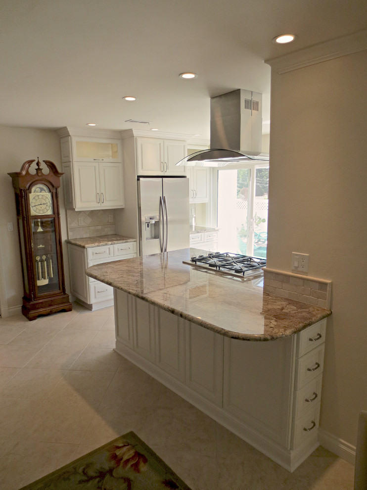 Inspiration for a mid-sized timeless l-shaped travertine floor kitchen remodel in San Diego with an undermount sink, raised-panel cabinets, white cabinets, granite countertops, beige backsplash, cement tile backsplash, stainless steel appliances and an island