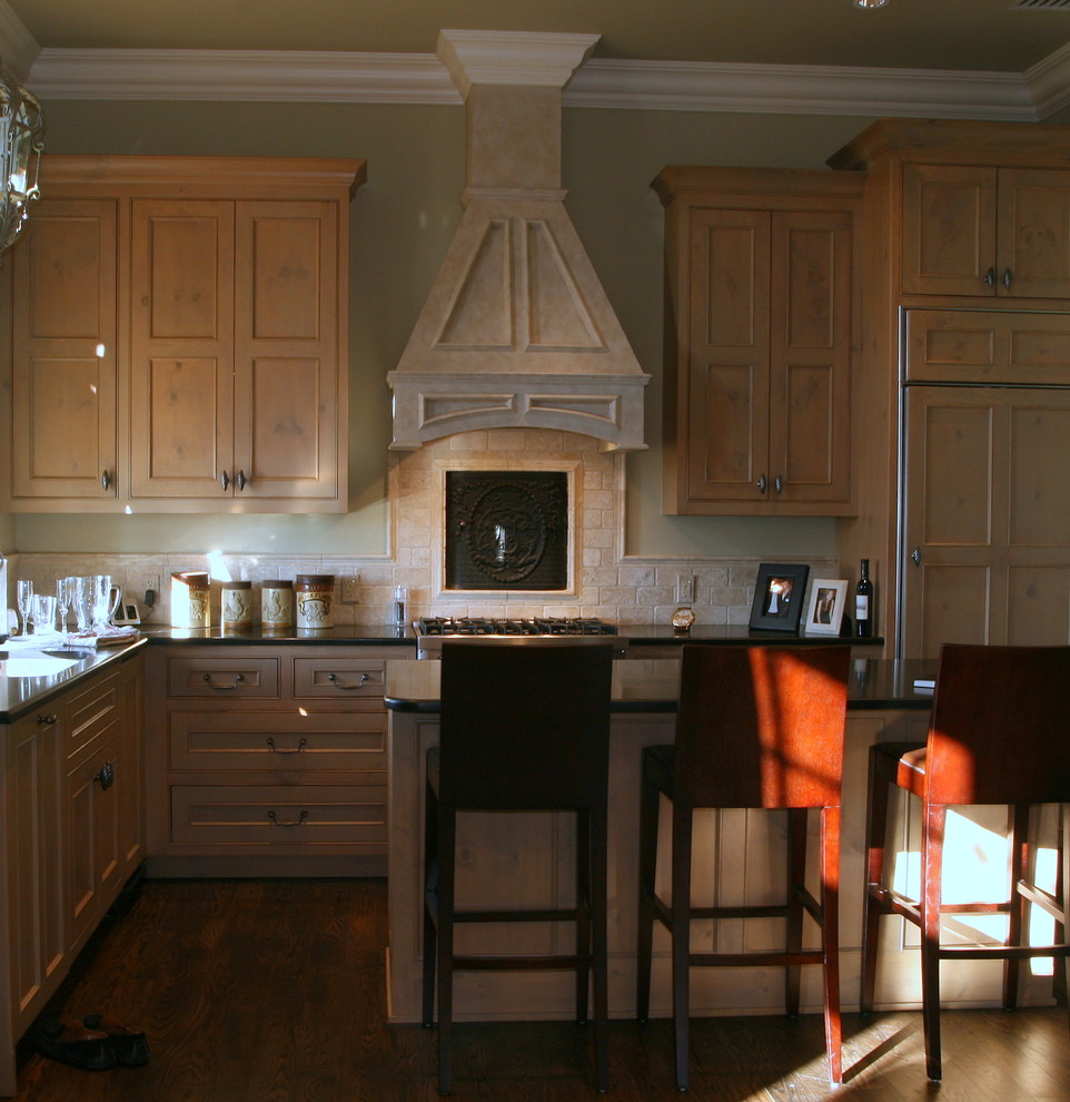 This is an example of a small traditional l-shaped enclosed kitchen in Other with a submerged sink, beaded cabinets, light wood cabinets, granite worktops, beige splashback, stone tiled splashback, integrated appliances, dark hardwood flooring and an island.