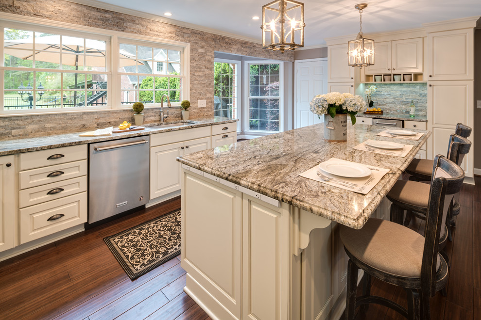 Inspiration for a large timeless u-shaped bamboo floor and brown floor eat-in kitchen remodel in Atlanta with an undermount sink, raised-panel cabinets, white cabinets, granite countertops, stainless steel appliances, an island, brown backsplash, stone tile backsplash and multicolored countertops