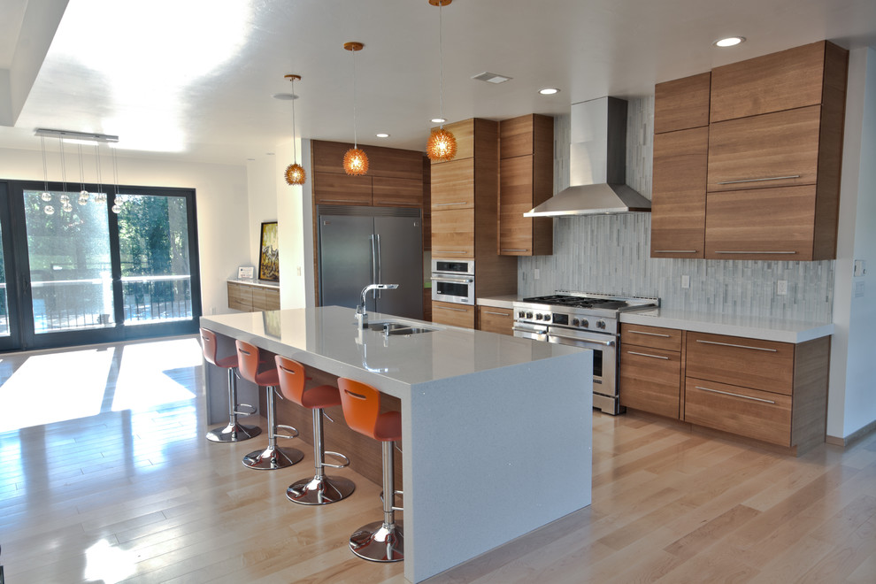 Large minimalist l-shaped light wood floor eat-in kitchen photo in Other with an undermount sink, flat-panel cabinets, light wood cabinets, quartz countertops, blue backsplash, mosaic tile backsplash, stainless steel appliances and an island