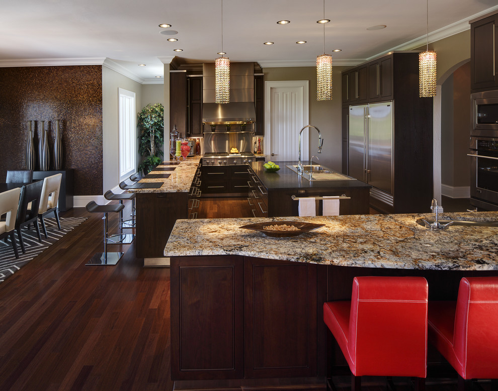 Inspiration for a modern eat-in kitchen remodel in Milwaukee with flat-panel cabinets, brown cabinets, granite countertops, metallic backsplash, stainless steel appliances and a drop-in sink