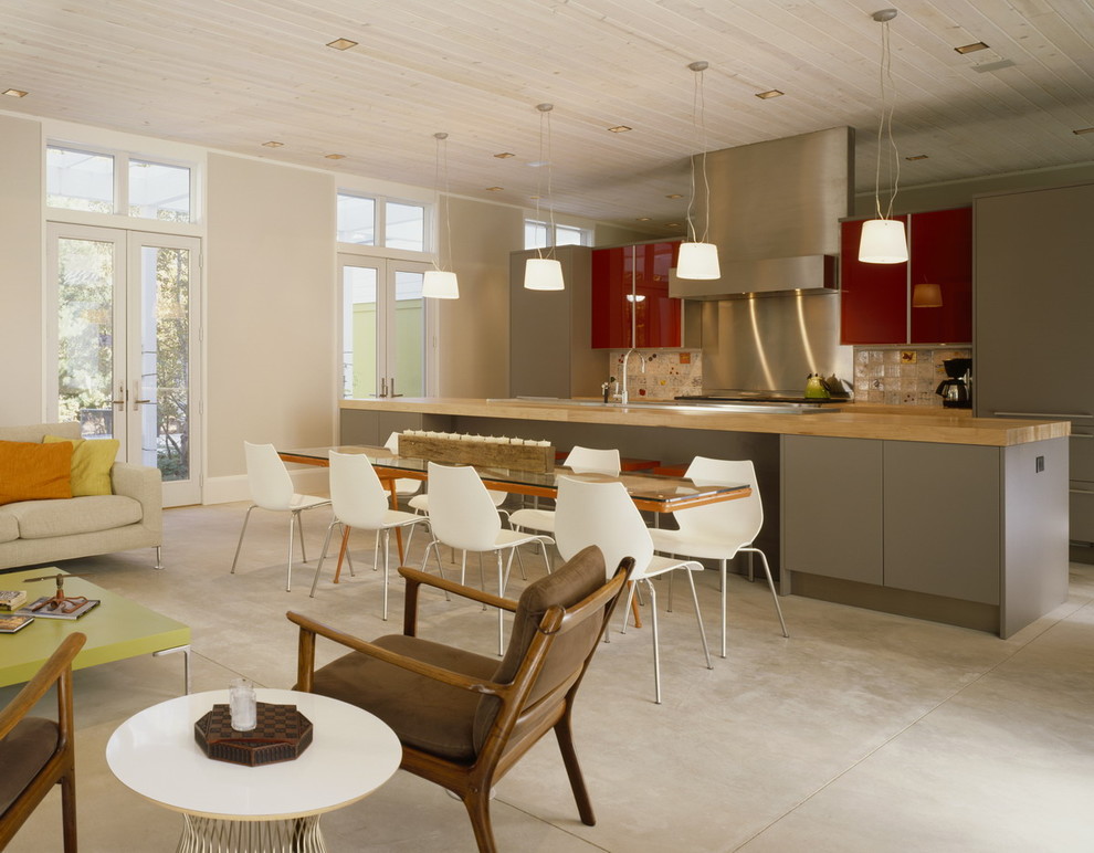 Exempel på ett 50 tals kök, med släta luckor, röda skåp, rostfria vitvaror och flerfärgad stänkskydd