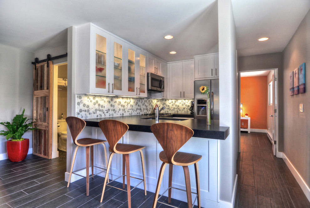Example of an island style kitchen design in Orange County with glass-front cabinets