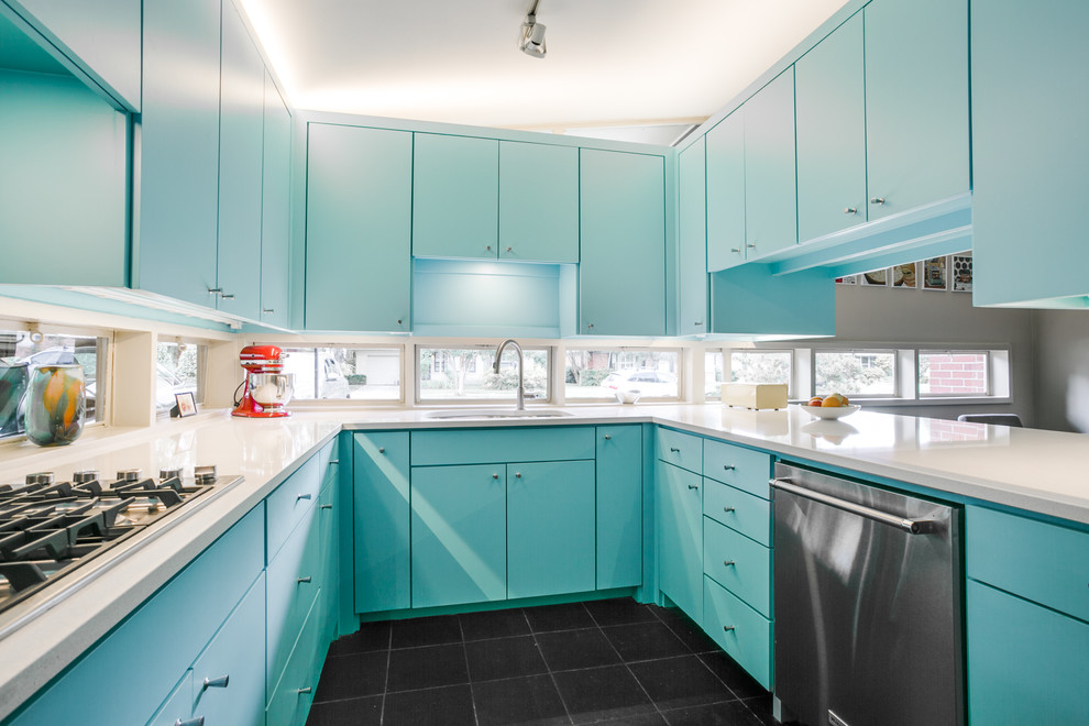 This is an example of a medium sized midcentury u-shaped enclosed kitchen in Dallas with a submerged sink, flat-panel cabinets, blue cabinets, stainless steel appliances, engineered stone countertops, window splashback, slate flooring and black floors.