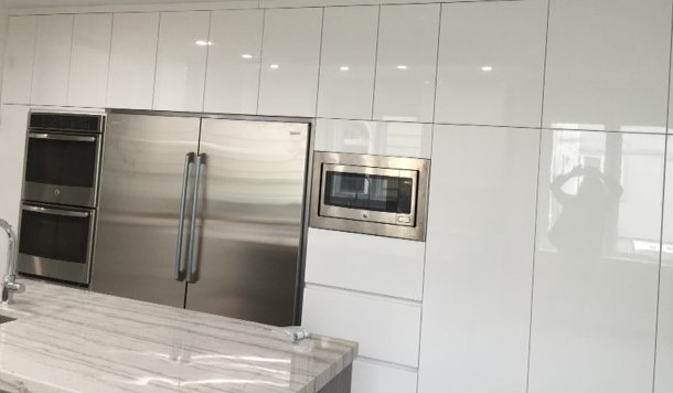 Foto di un grande cucina con isola centrale minimalista chiuso con lavello sottopiano, ante lisce, ante bianche, elettrodomestici in acciaio inossidabile e top in quarzite