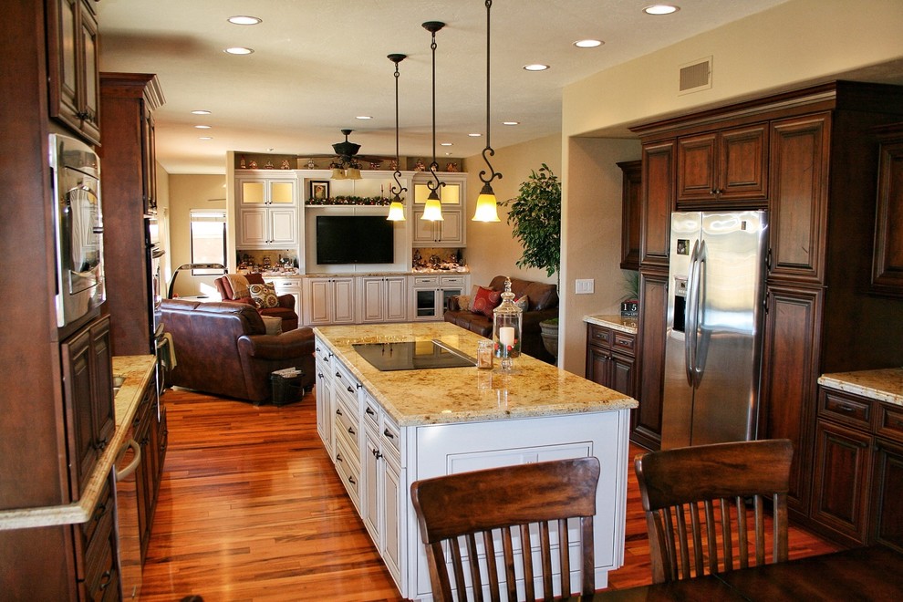 Exempel på ett stort klassiskt beige beige kök, med en undermonterad diskho, luckor med upphöjd panel, skåp i mellenmörkt trä, granitbänkskiva, beige stänkskydd, stänkskydd i stenkakel, rostfria vitvaror, mellanmörkt trägolv, en köksö och brunt golv