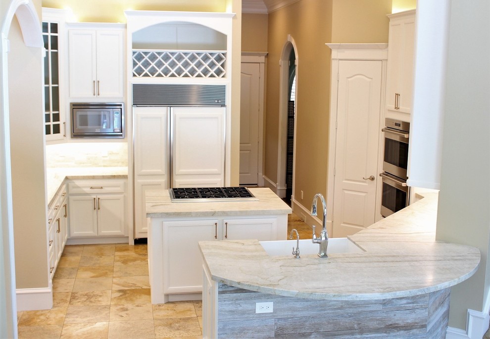 Large transitional u-shaped travertine floor and beige floor eat-in kitchen photo in Houston with a farmhouse sink, recessed-panel cabinets, white cabinets, quartzite countertops, beige backsplash, limestone backsplash, stainless steel appliances and two islands