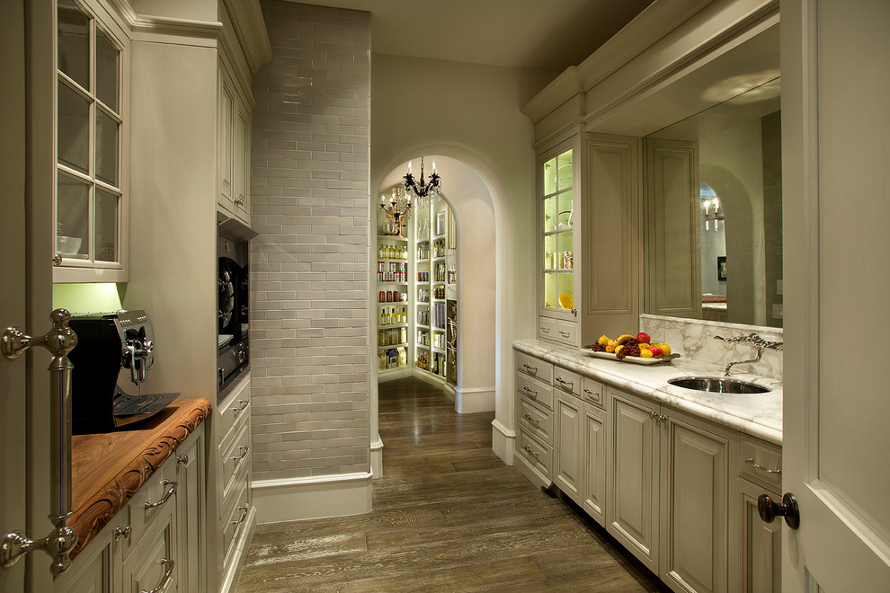 Exempel på ett mycket stort klassiskt kök, med luckor med upphöjd panel, marmorbänkskiva, rostfria vitvaror, mellanmörkt trägolv, en rustik diskho, vita skåp, beige stänkskydd, stänkskydd i marmor och brunt golv