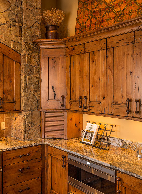 Inspiration for a rustic kitchen in Denver with medium wood cabinets, granite worktops, stainless steel appliances, light hardwood flooring and an island.