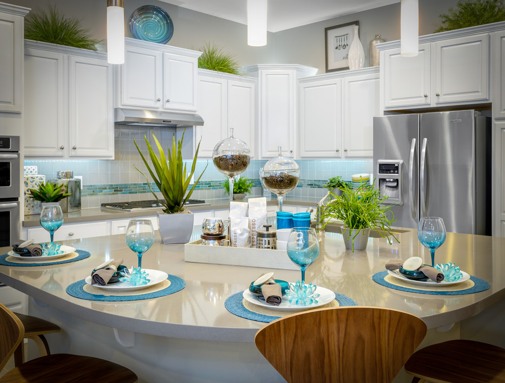 Example of a mid-sized trendy l-shaped ceramic tile open concept kitchen design in Phoenix with a drop-in sink, flat-panel cabinets, white cabinets, quartzite countertops, multicolored backsplash, ceramic backsplash, stainless steel appliances and an island