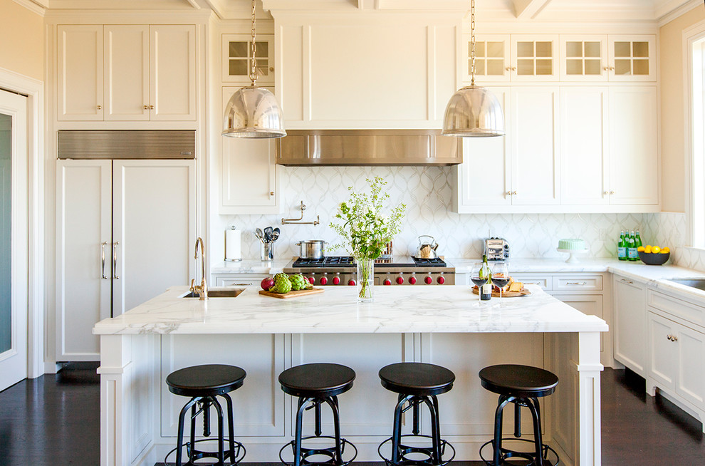 Design ideas for a traditional l-shaped kitchen in San Francisco with shaker cabinets, white cabinets, white splashback, integrated appliances, dark hardwood flooring, an island and brown floors.