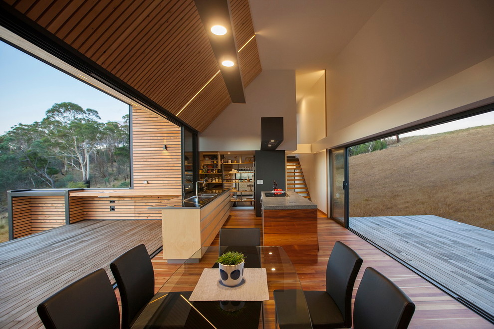 Inspiration pour une grande cuisine ouverte parallèle design avec un sol en bois brun et 2 îlots.