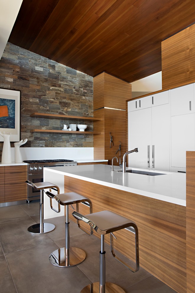 Immagine di una cucina a L minimal con lavello sottopiano, ante a filo, ante bianche, elettrodomestici in acciaio inossidabile e pavimento grigio