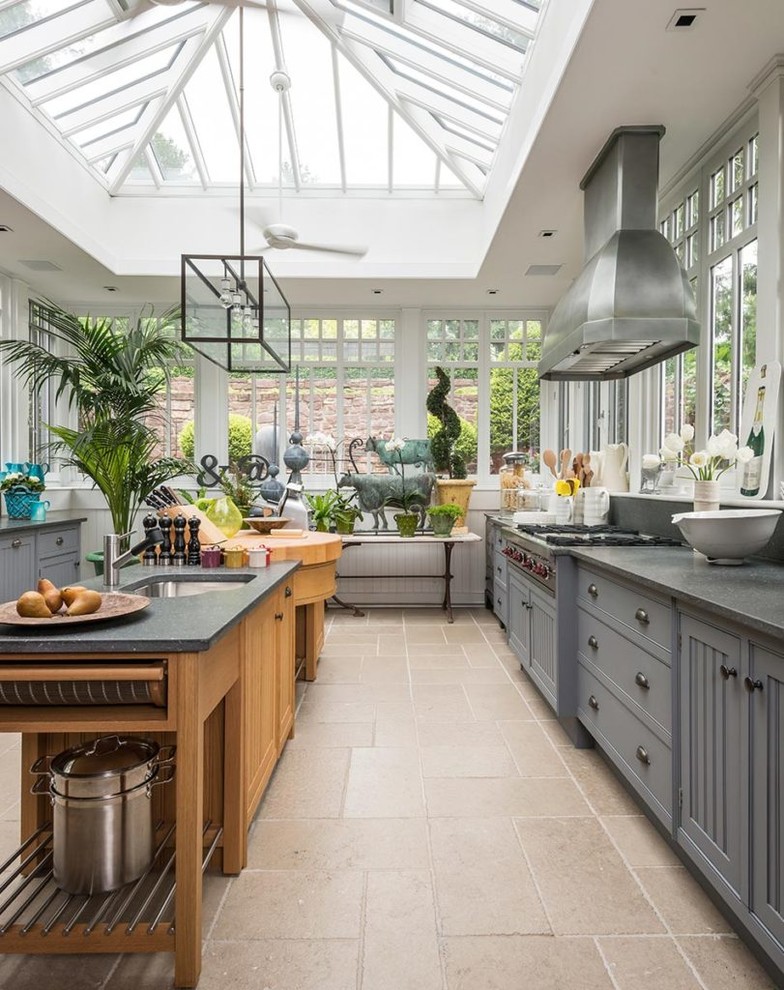 Zweizeilige Landhaus Küche mit Unterbauwaschbecken, grauen Schränken, Rückwand-Fenster, Kücheninsel und beigem Boden in Sonstige