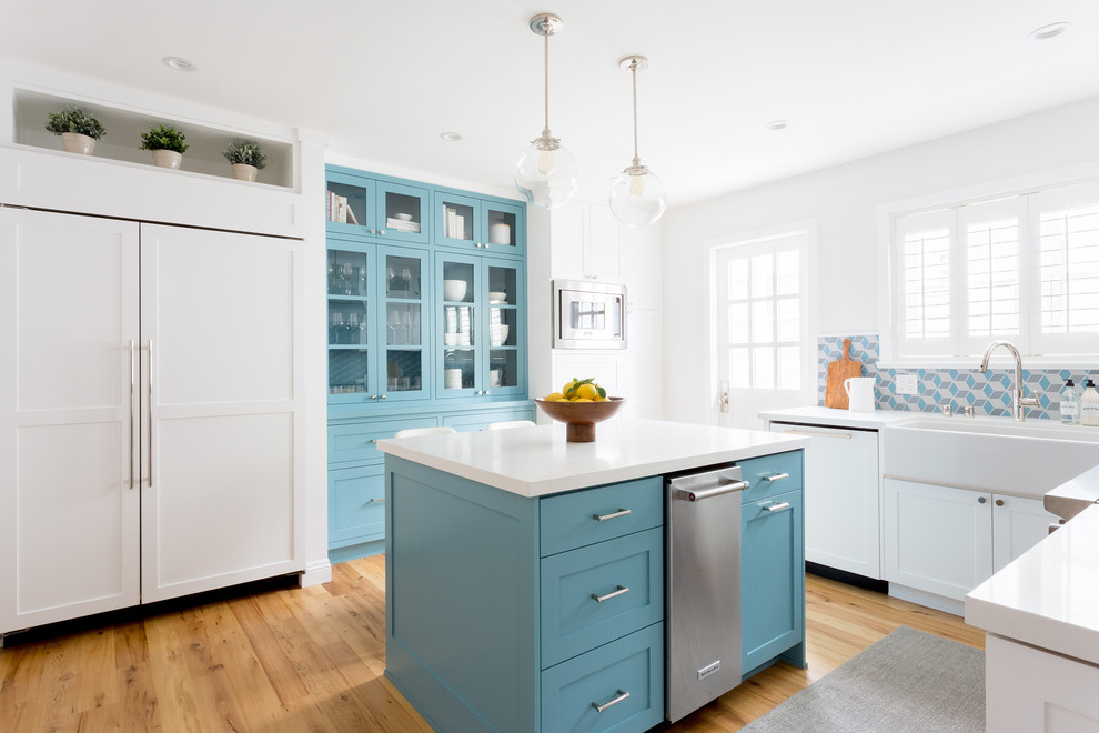 Klassische Küche in U-Form mit Landhausspüle, Schrankfronten im Shaker-Stil, blauen Schränken, bunter Rückwand, Rückwand aus Mosaikfliesen, braunem Holzboden, Kücheninsel und braunem Boden in Los Angeles