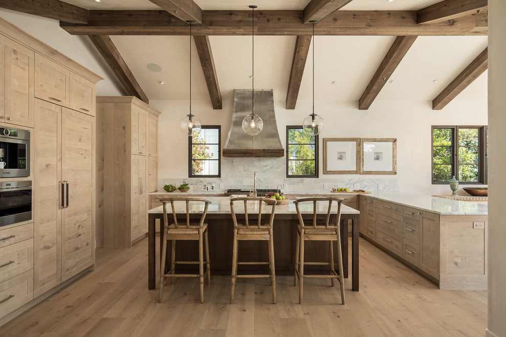 Inspiration for a mediterranean u-shaped light wood floor and beige floor open concept kitchen remodel in San Luis Obispo with shaker cabinets, light wood cabinets, gray backsplash, paneled appliances and an island
