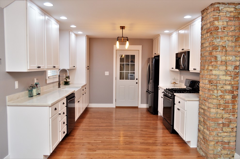 Medium sized farmhouse galley open plan kitchen in Chicago with a belfast sink, shaker cabinets, white cabinets, composite countertops, no island and white worktops.