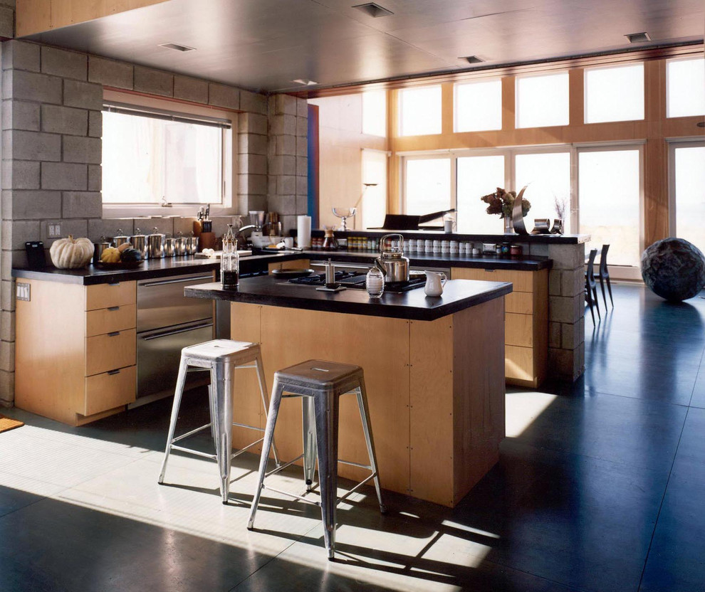 Imagen de cocinas en L contemporánea con armarios con paneles lisos, puertas de armario de madera clara y electrodomésticos de acero inoxidable