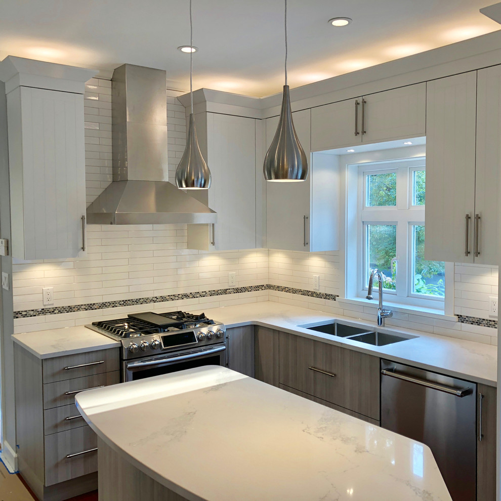 Example of a mid-sized minimalist galley medium tone wood floor and red floor eat-in kitchen design in Vancouver with a double-bowl sink, flat-panel cabinets, gray cabinets, quartz countertops, white backsplash, subway tile backsplash, stainless steel appliances, an island and white countertops