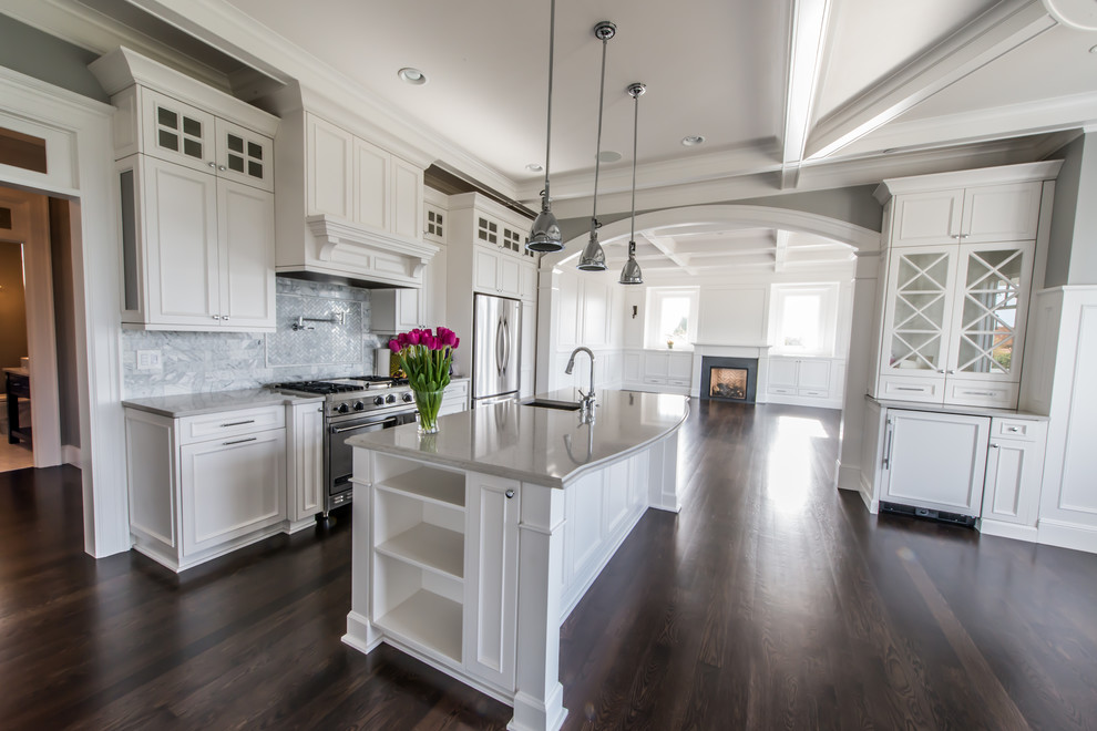 Example of a large classic u-shaped dark wood floor eat-in kitchen design in Portland with a drop-in sink, raised-panel cabinets, white cabinets, soapstone countertops, white backsplash, marble backsplash, stainless steel appliances and an island