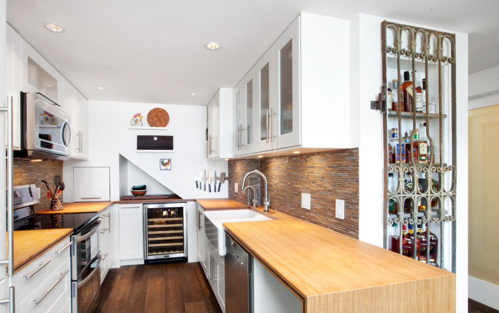 Example of a small trendy u-shaped dark wood floor eat-in kitchen design in Vancouver with no island, a farmhouse sink, white cabinets, wood countertops, multicolored backsplash, matchstick tile backsplash and stainless steel appliances