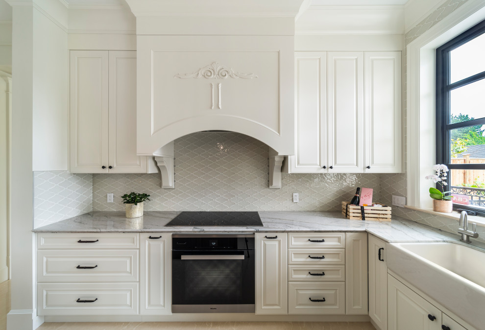 Idéer för stora vintage grått kök, med en dubbel diskho, luckor med infälld panel, vita skåp, marmorbänkskiva, vitt stänkskydd, stänkskydd i keramik, integrerade vitvaror, marmorgolv, en köksö och beiget golv