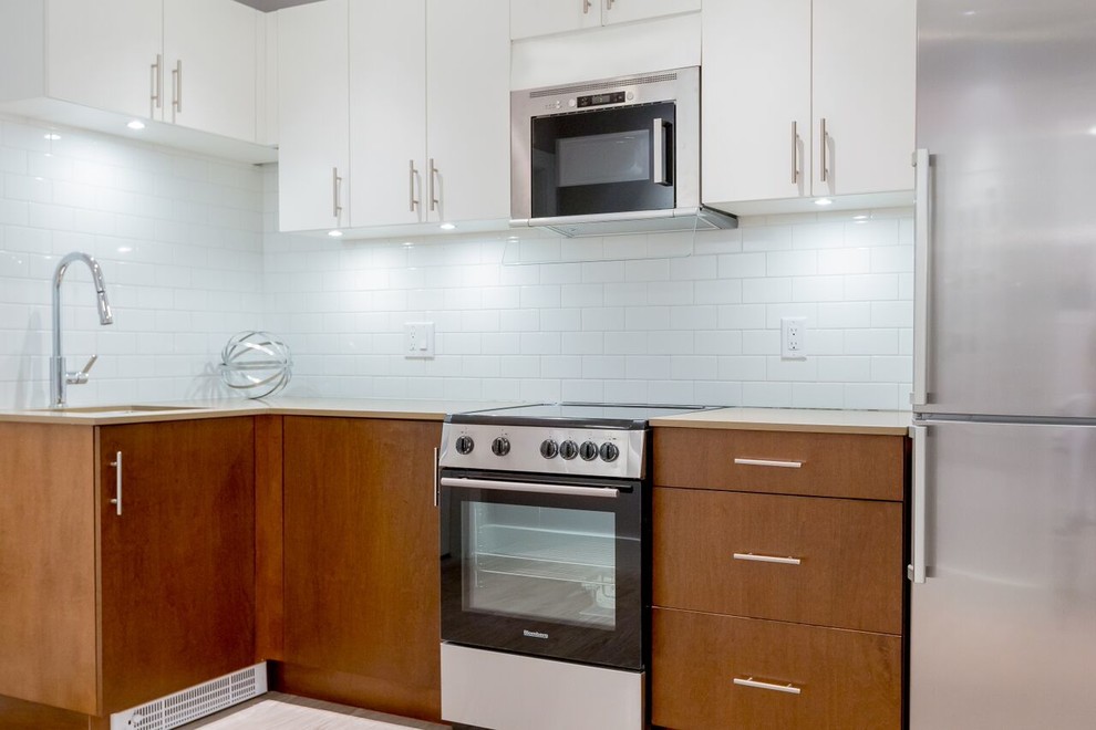 Ispirazione per una piccola cucina minimal con lavello sottopiano, ante bianche, paraspruzzi bianco, elettrodomestici in acciaio inossidabile, nessuna isola, ante lisce, top in superficie solida, paraspruzzi con piastrelle diamantate e pavimento in gres porcellanato