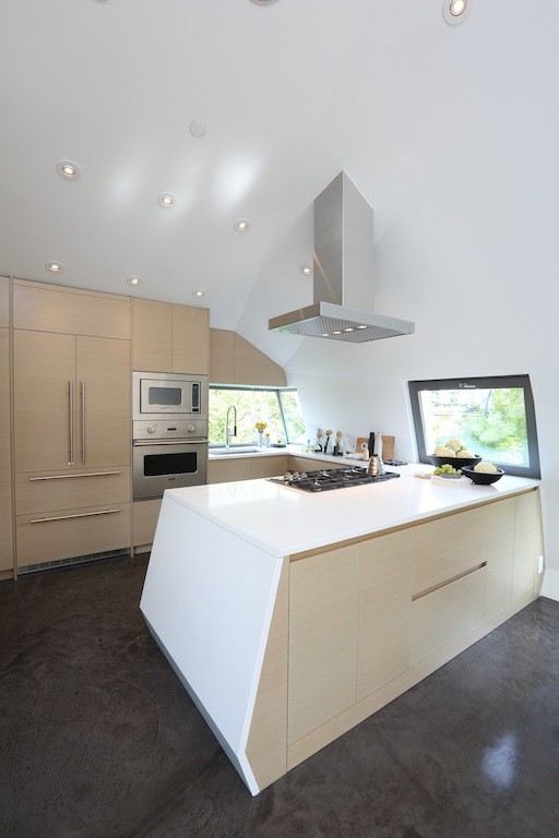Foto de cocina comedor contemporánea de tamaño medio con puertas de armario de madera clara, electrodomésticos de acero inoxidable, suelo de cemento, una isla y fregadero encastrado