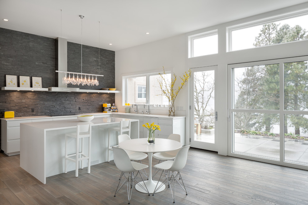 Example of a trendy eat-in kitchen design in Portland with flat-panel cabinets, white cabinets, gray backsplash and slate backsplash