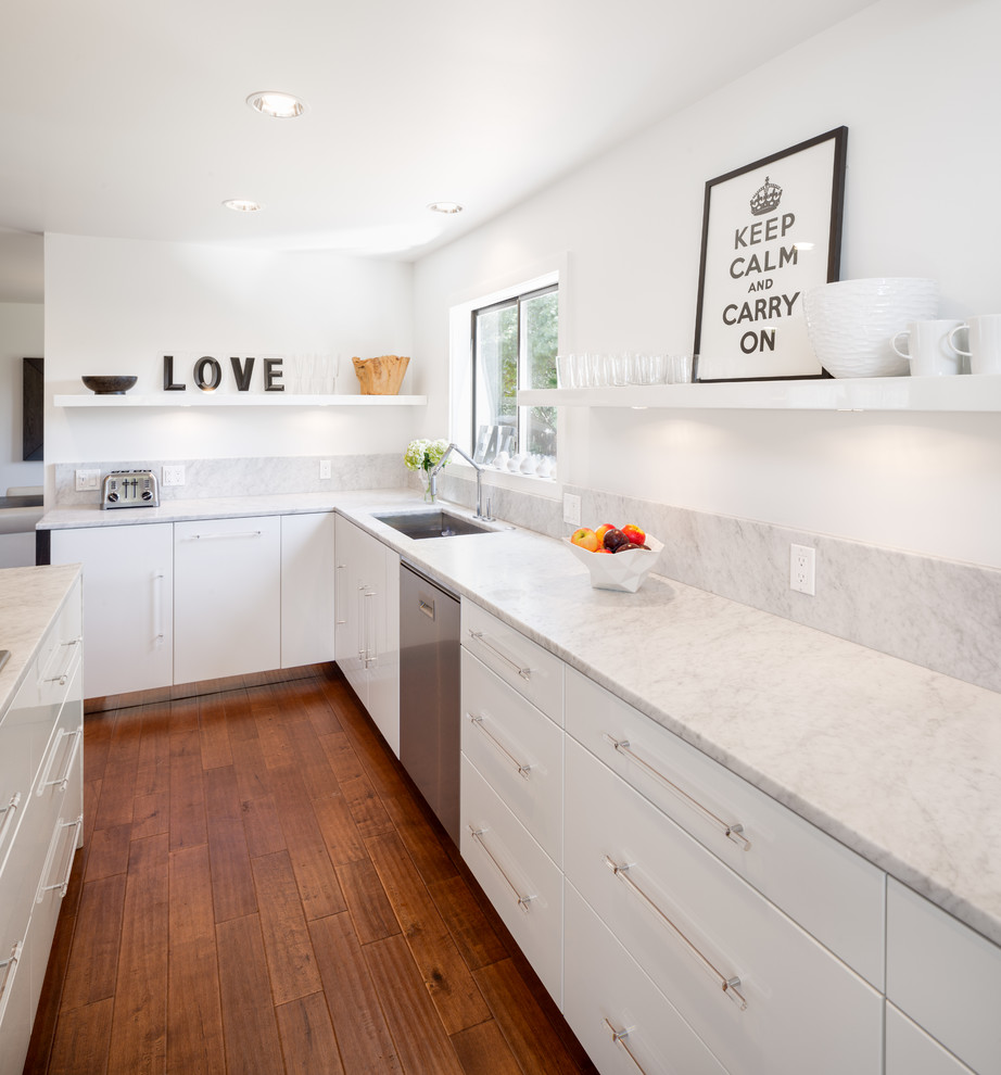 Moderne Küche mit Unterbauwaschbecken, flächenbündigen Schrankfronten, weißen Schränken und Küchengeräten aus Edelstahl in Portland