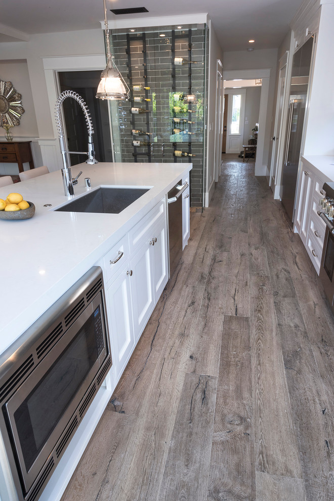 Idee per una cucina design con ante in legno chiaro, top in quarzite, pavimento in legno massello medio e elettrodomestici in acciaio inossidabile