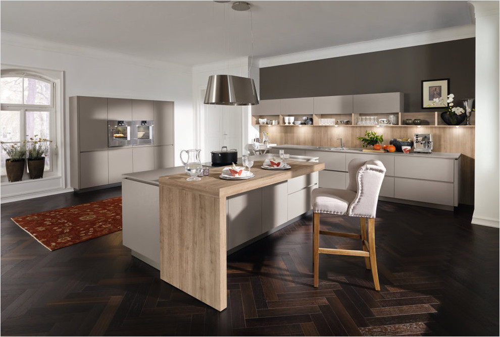 Mid-sized minimalist l-shaped dark wood floor eat-in kitchen photo in New York with a drop-in sink, flat-panel cabinets, beige cabinets, wood countertops, wood backsplash, stainless steel appliances and an island