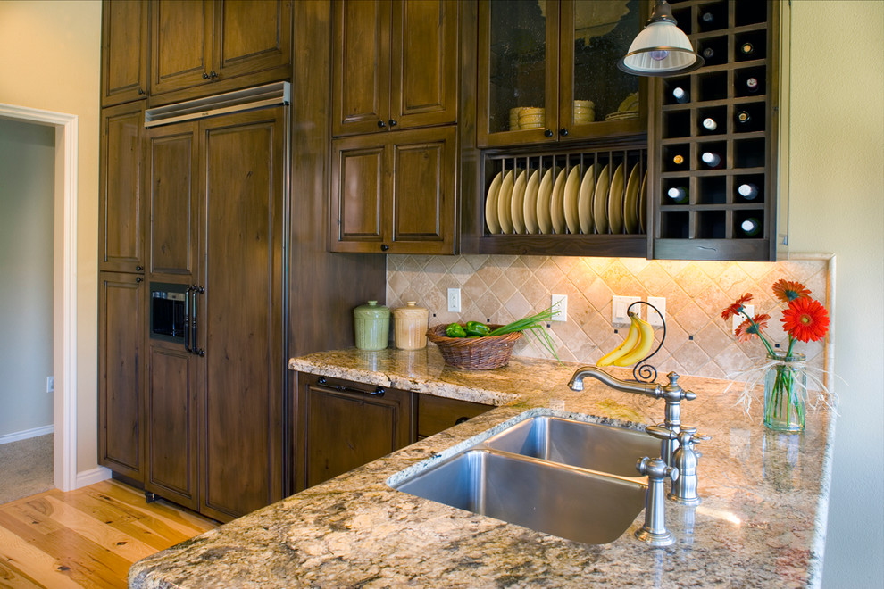 Bild på ett mellanstort vintage kök och matrum, med en undermonterad diskho, luckor med upphöjd panel, skåp i mellenmörkt trä, granitbänkskiva, vitt stänkskydd, stänkskydd i keramik, ljust trägolv och en halv köksö