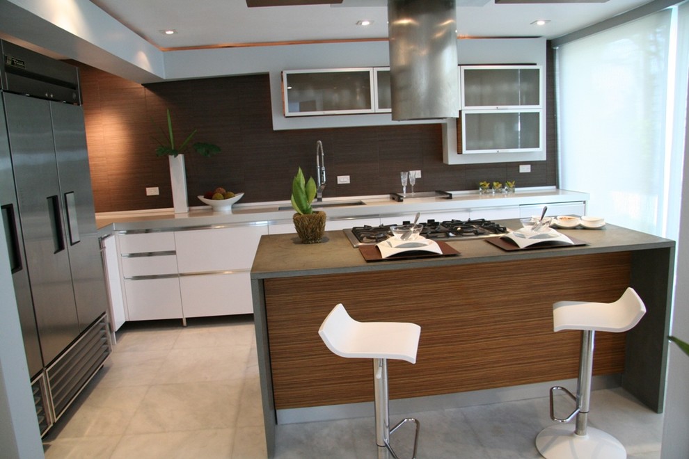 Example of a mid-sized minimalist l-shaped marble floor eat-in kitchen design in Miami with a double-bowl sink, flat-panel cabinets, white cabinets, limestone countertops, brown backsplash, ceramic backsplash, stainless steel appliances and an island
