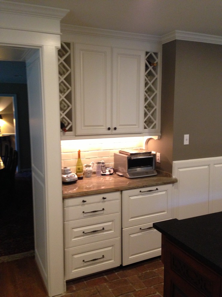 Klassische Küche mit profilierten Schrankfronten, weißen Schränken, Granit-Arbeitsplatte, Küchenrückwand in Beige, Rückwand aus Keramikfliesen, Backsteinboden und rotem Boden in Houston