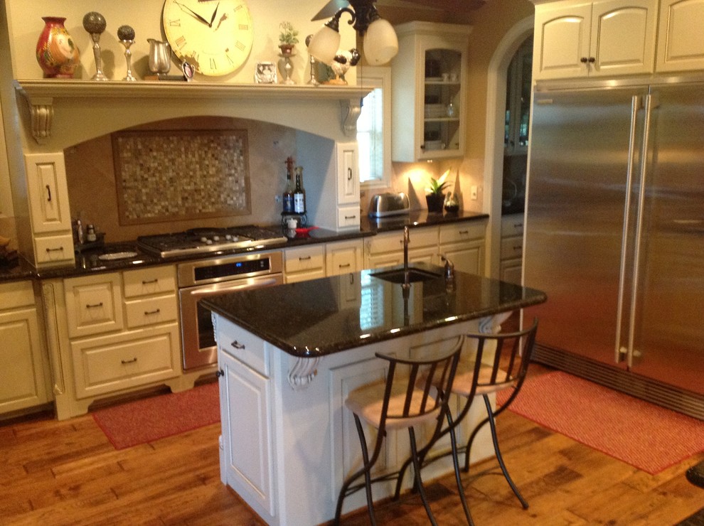 Bild på ett stort vintage kök, med en dubbel diskho, luckor med upphöjd panel, vita skåp, bänkskiva i onyx, beige stänkskydd, stänkskydd i keramik, rostfria vitvaror, ljust trägolv och en köksö