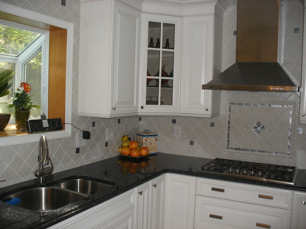 This is an example of a medium sized classic l-shaped open plan kitchen in New York with a submerged sink, raised-panel cabinets, white cabinets, engineered stone countertops, multi-coloured splashback, mosaic tiled splashback, stainless steel appliances and porcelain flooring.