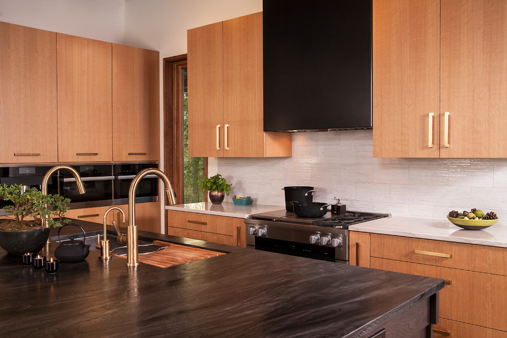 This is an example of a large world-inspired single-wall kitchen/diner in Seattle with black worktops, a submerged sink, flat-panel cabinets, light wood cabinets, wood worktops, grey splashback, porcelain flooring, an island and grey floors.